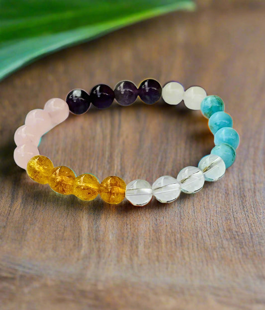 Multicolored beaded bracelet on a white background with flowers.