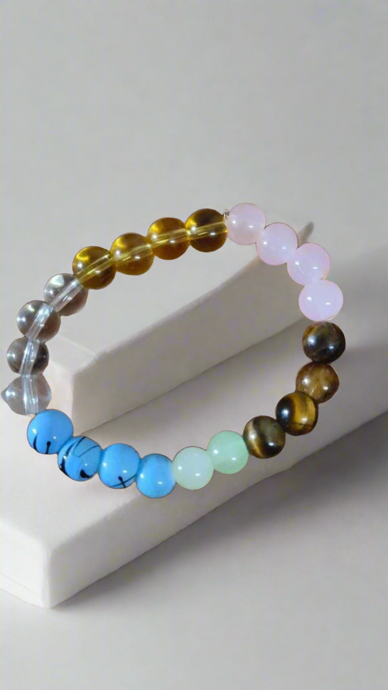 Multicolored beaded bracelet on a hand against a neutral background